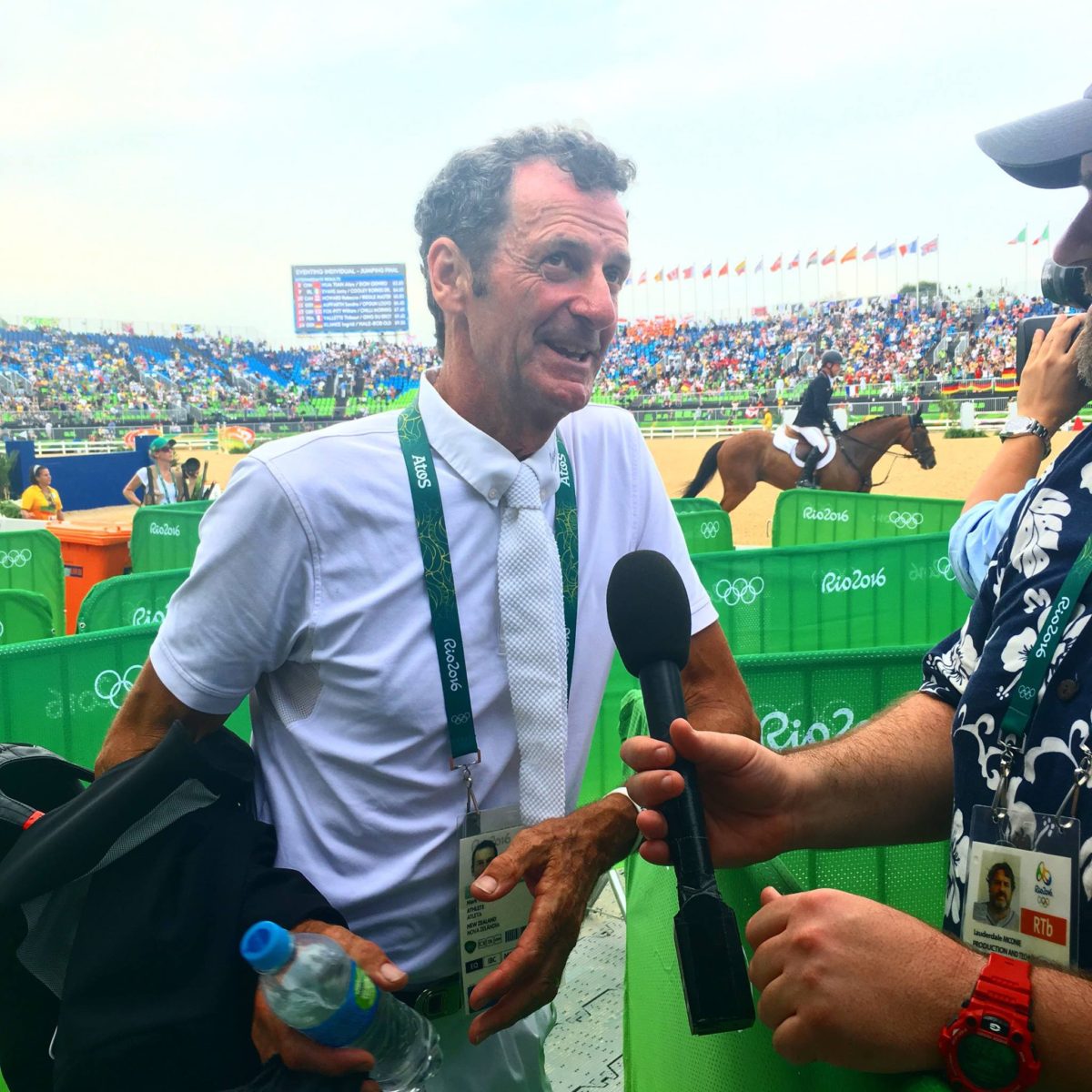 Sir Mark talking to media while Michael Jung on Sam (behind him in this photo) make history by joining him as consecutive gold medal winners (Image: Jane Thompson)